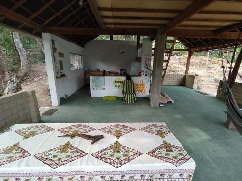 a room with a table in the middle of a house at Kombi Hostel Camping in Vale do Capao