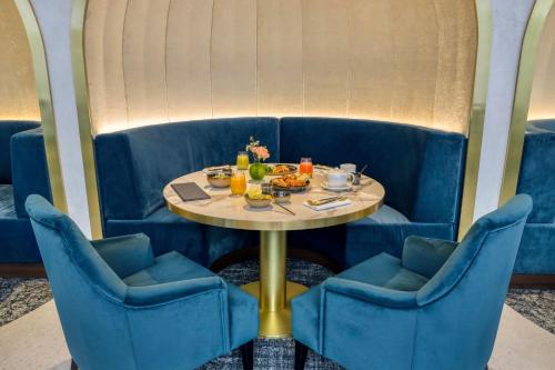 une cabine bleue avec une table et deux chaises dans l'établissement Maison Albar - Le Vendome, à Paris