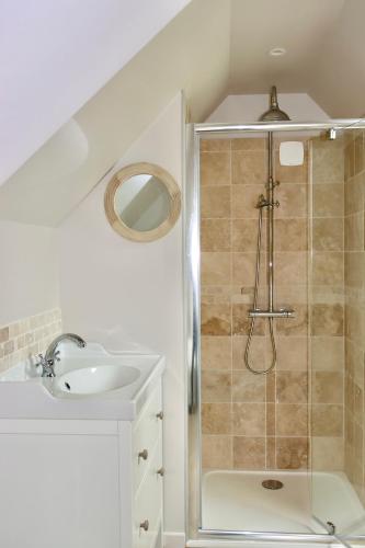 une salle de bain avec douche et lavabo dans l'établissement Les maisons de Charlotte (2), à Glanville
