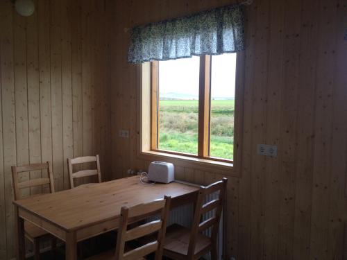 una mesa de madera en una habitación con ventana en Cabin 1 at Lundar Farm, en Borgarnes