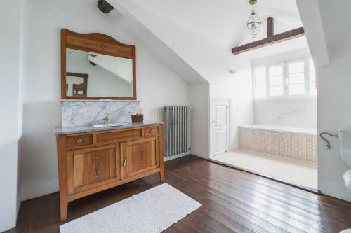 a bathroom with a sink and a mirror and a tub at La Casona de Amandi in Villaviciosa