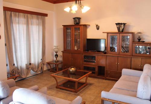 a living room with couches and a tv and a table at Balcony of Koroni in Koroni