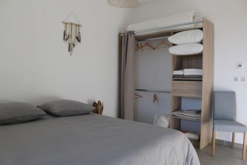a bedroom with a bed and a chair and towels at APPT NEUF haut de gamme, Terrasse, Sud Montpellier in Pérols