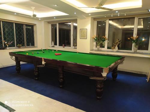 a green pool table in a room with windows at Sher-E-Punjab in Kolkata