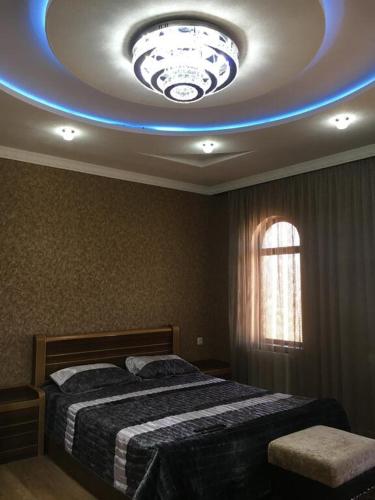 a bedroom with a bed and a ceiling with a blue light at Gricko in Tbilisi City