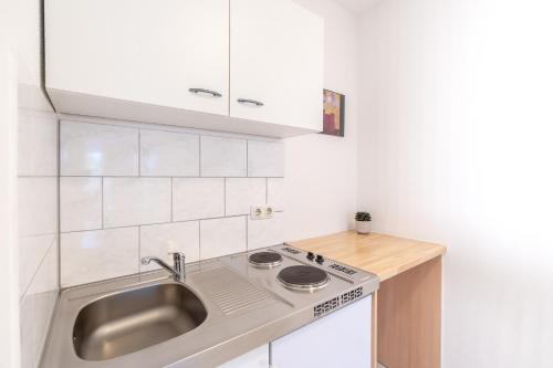 a kitchen with a sink and a counter top at Hotel Fresh INN in Unterhaching