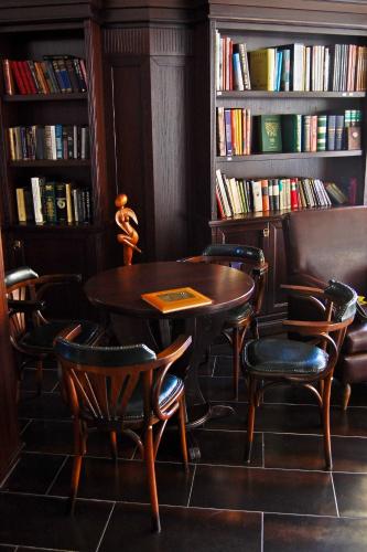 a table and chairs in a room with books at Hill Hotel Wellness & Spa in Jagodina
