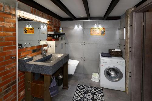 a bathroom with a sink and a washing machine at Loft Szpularnia in Żyrardów