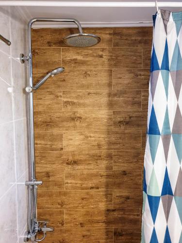 a shower in a bathroom with a wooden wall at City House Loft in Kalamata