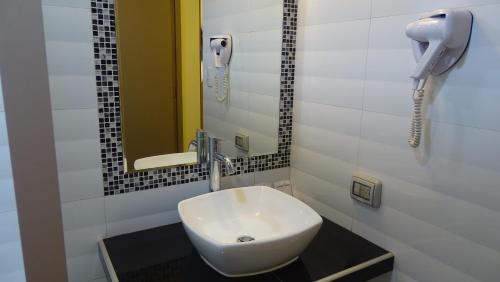 a bathroom with a white sink and a phone at Suites Larco 656 Miraflores Lima in Lima