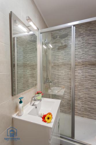 a bathroom with a white sink and a shower at Apartamento da estação in Setúbal