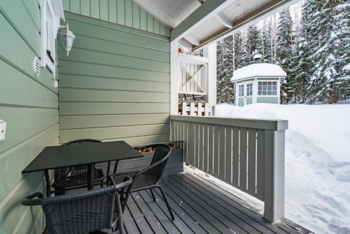 a porch with two chairs and a table on it at Lomaperkkiö Apartments in Vuokatti