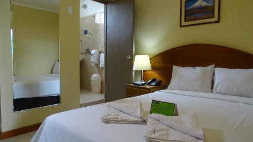 a hotel room with a bed with a book on it at Suites Larco 656 Miraflores Lima in Lima