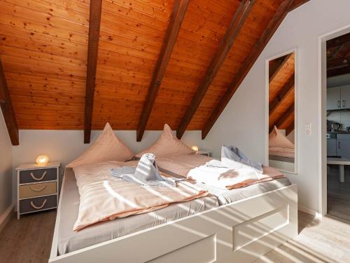カロリーネンジールにあるFerienwohnanlage Lübbenの木製天井の客室の大型ベッド1台分です。