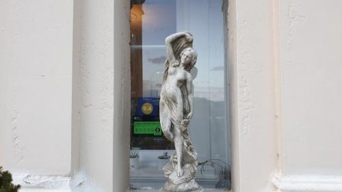 a statue of a woman standing in a window at Longworth Hall Hotel in Hereford