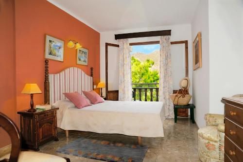 a bedroom with a bed and a window at Hostal Los Pinos in Cala de Sant Vicenc