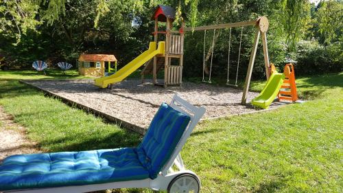 a playground with a chair and a slide at Logis SPA Hotel Restaurant De La Poste in Tence