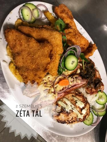 a plate of food with fish and vegetables on it at Hotel Zéta in Lenti