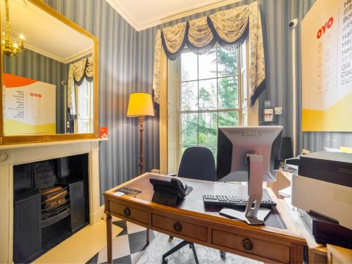 a living room filled with furniture and a fireplace at OYO Bailbrook Lodge in Bath