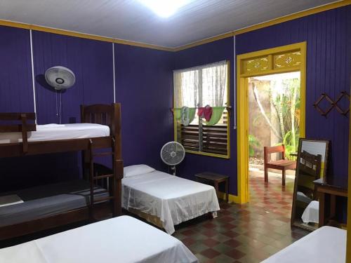 a room with two bunk beds and a window at Casa Romano Hostel in San Juan del Sur