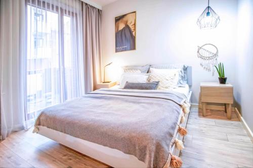 - une chambre avec un grand lit et une grande fenêtre dans l'établissement Apartament Arkadia na Kazimierzu, à Cracovie