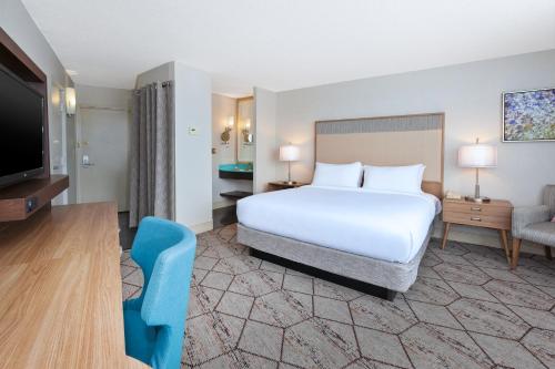 a hotel room with a bed and a flat screen tv at Crowne Plaza Syracuse, an IHG Hotel in Syracuse