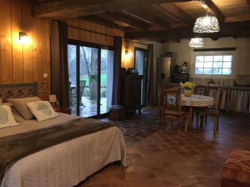 une chambre avec un lit et une table et une cuisine dans l'établissement la garçonnière, à Nivillac