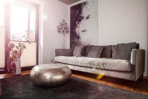 ein Wohnzimmer mit einem Sofa und einem Metallottoman in der Unterkunft IchZeit Aparthotel in Cochem