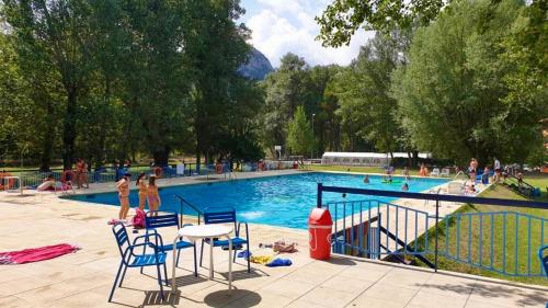 a swimming pool with chairs and people in a park at Casa Parranxo in Senterada