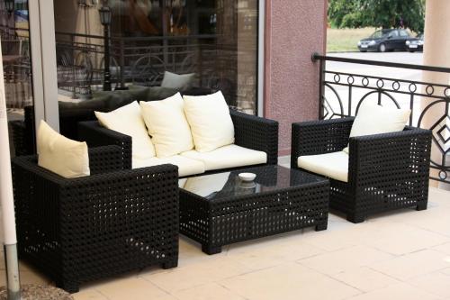 a set of wicker chairs and a coffee table on a porch at Hill Hotel Wellness & Spa in Jagodina