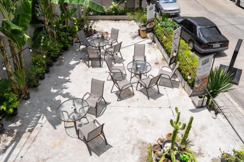 a group of tables and chairs sitting on a sidewalk at W Station in Bangkok