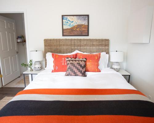 a bedroom with a large bed with orange pillows at RubyJune Inn in White Salmon