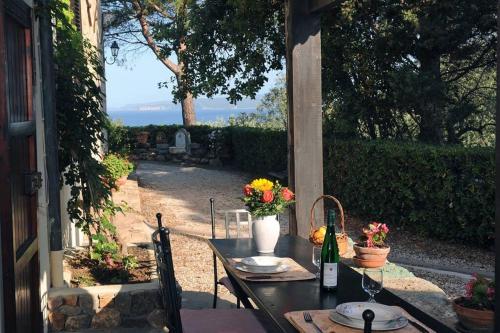a table with a bottle of wine and flowers on it at Dépendance Viburni in Alghero