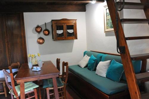 a living room with a green couch and a table at Dépendance Viburni in Alghero
