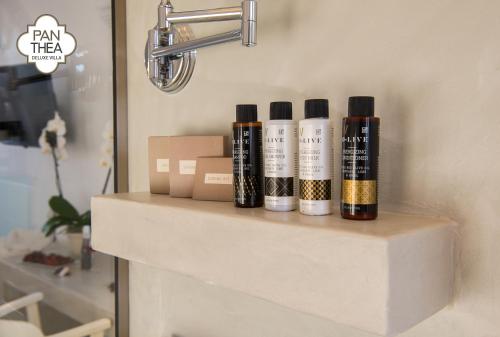a group of four bottles sitting on a shelf at Villa Panthea in Líndos
