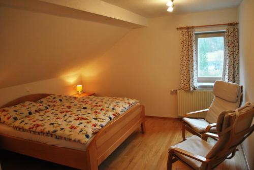 ルンツ・アム・ゼーにあるFerienwohnung Leitnerのベッドルーム1室(ベッド1台、椅子、窓付)