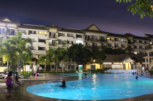 una piscina frente a un hotel por la noche en One oasis A2, shortwalk SM MALL Free POOL Kitchen, en Davao City