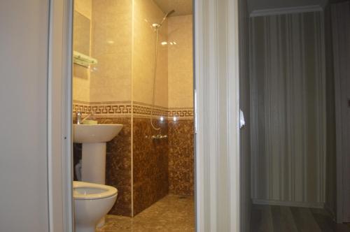 a bathroom with a toilet and a sink and a shower at hill-fort kutaisi in Kutaisi