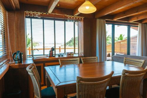 a dining room with a wooden table and chairs at Hotel Atalaia do Mariscal in Bombinhas