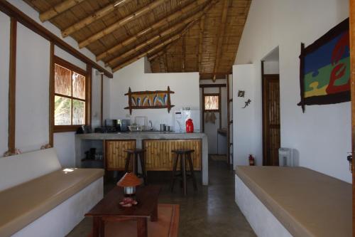 a living room with a kitchen and a table at Hoja de Palma Bungalows in Canoas de Punta Sal