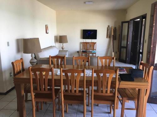 a dining room with a wooden table and chairs at Casa BEIRA MAR Praia do Grant em Barra Velha-SC in Barra Velha