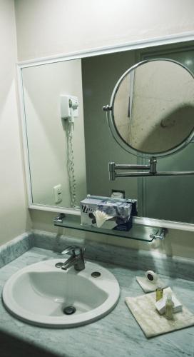 a bathroom with a sink and a mirror at Hotel Fortin Plaza in Oaxaca City