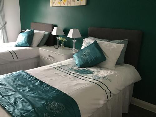 Un dormitorio con dos camas con almohadas azules y blancas. en Garron View, en Cushendall