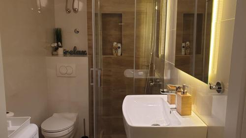 a bathroom with a toilet and a sink and a shower at City Break Apartments - City Zen in Belgrade