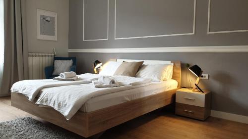 a bedroom with a large bed with white sheets and pillows at City Break Apartments - City Zen in Belgrade
