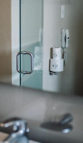 a mirror over a bathroom sink with a phone at Hotel Fortin Plaza in Oaxaca City