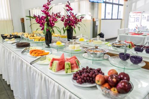 a long table with many plates of fruit on it at Pousada Paraiso in Guanambi