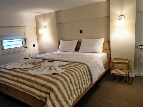 a bedroom with a large bed with towels on it at City House Loft in Kalamata