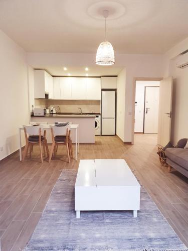 a living room with a white table and a kitchen at The Terrace House - Grémio in Olhão