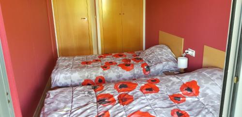 サン・ホルヘにあるRésidence Golf Panoramicaのベッドルーム1室(赤い花のベッド1台付)